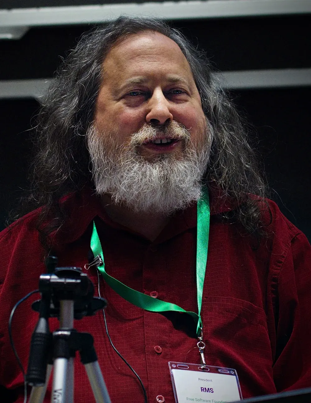 صورة ريتشارد ستالمان بشعر طويل ولحية رمادية وقميص أحمر يتحدث في مؤتمر LibrePlanet 2019