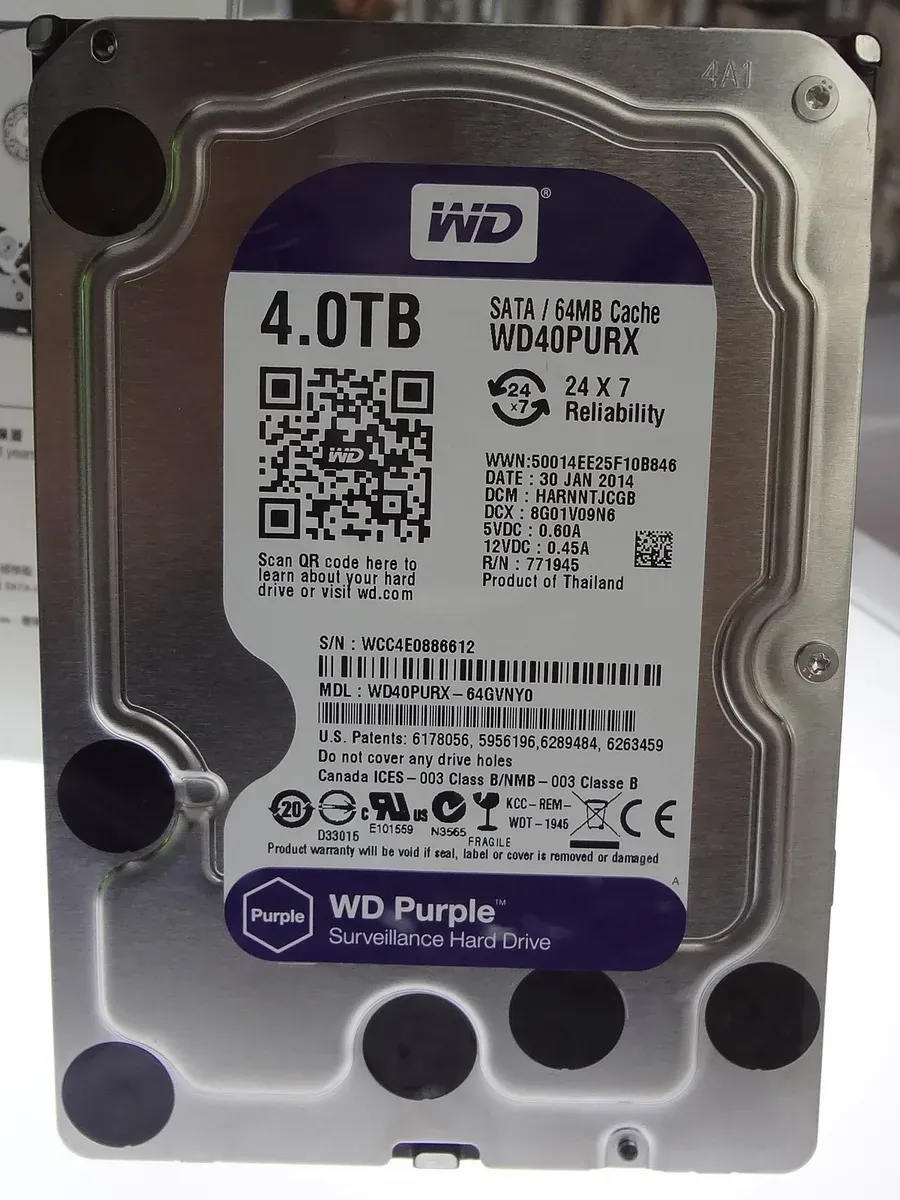 قرص صلب 3.5 بوصة من نوع WD Purple بسعة 4.0TB، على ملصقه الأرجواني عبارة Surveillance Hard Drive وعبارة 24x7 Reliability ورمز QR ورقم الموديل WD40PURX
